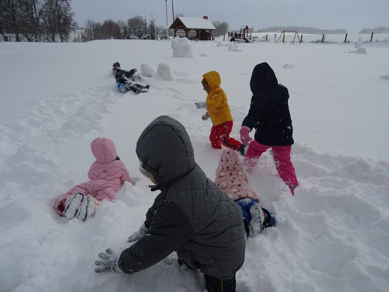 Posesja szkolna. Dzieci bawią się na śniegu.