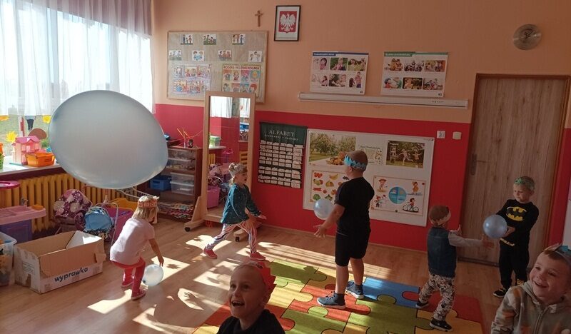 Sala dydaktyczna. Dzieci bawią się na podłodze balonikami.