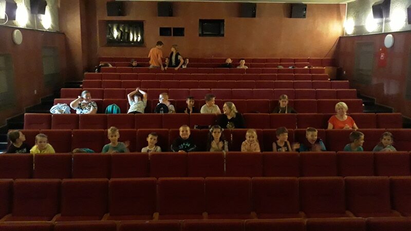 Kino "Mazur" w Olecku. Dzieci nauczyciele siedzą w fotelach.