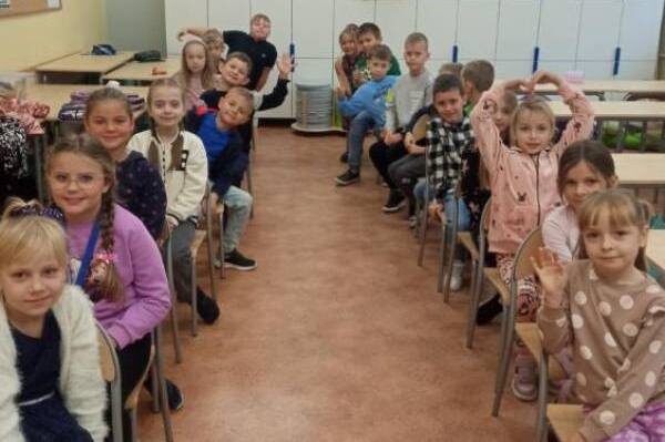 Szkoła Podstawowa nr 2 w Olecku. Sala dydaktyczna. Dzieci siedzą na krzesłach jedno za drugim.